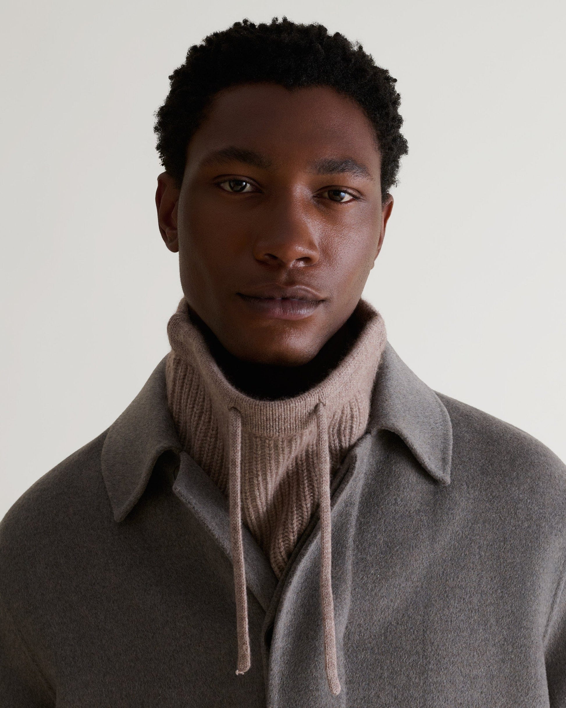 Man wearing toast cashmere merino drawstring snood with grey wool coat