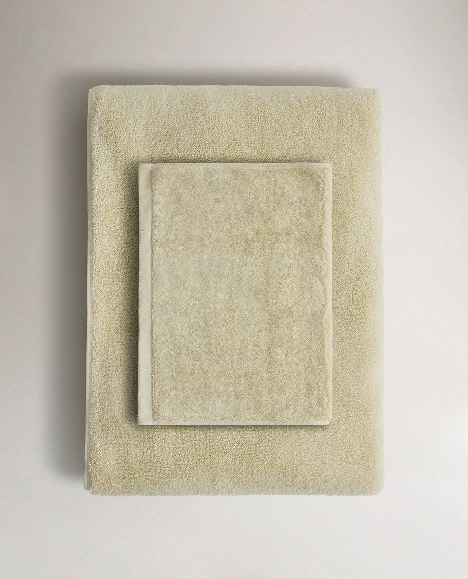 Rise & Fall's buttermilk Turkish cotton hand towel lying on top of matching bath towel
