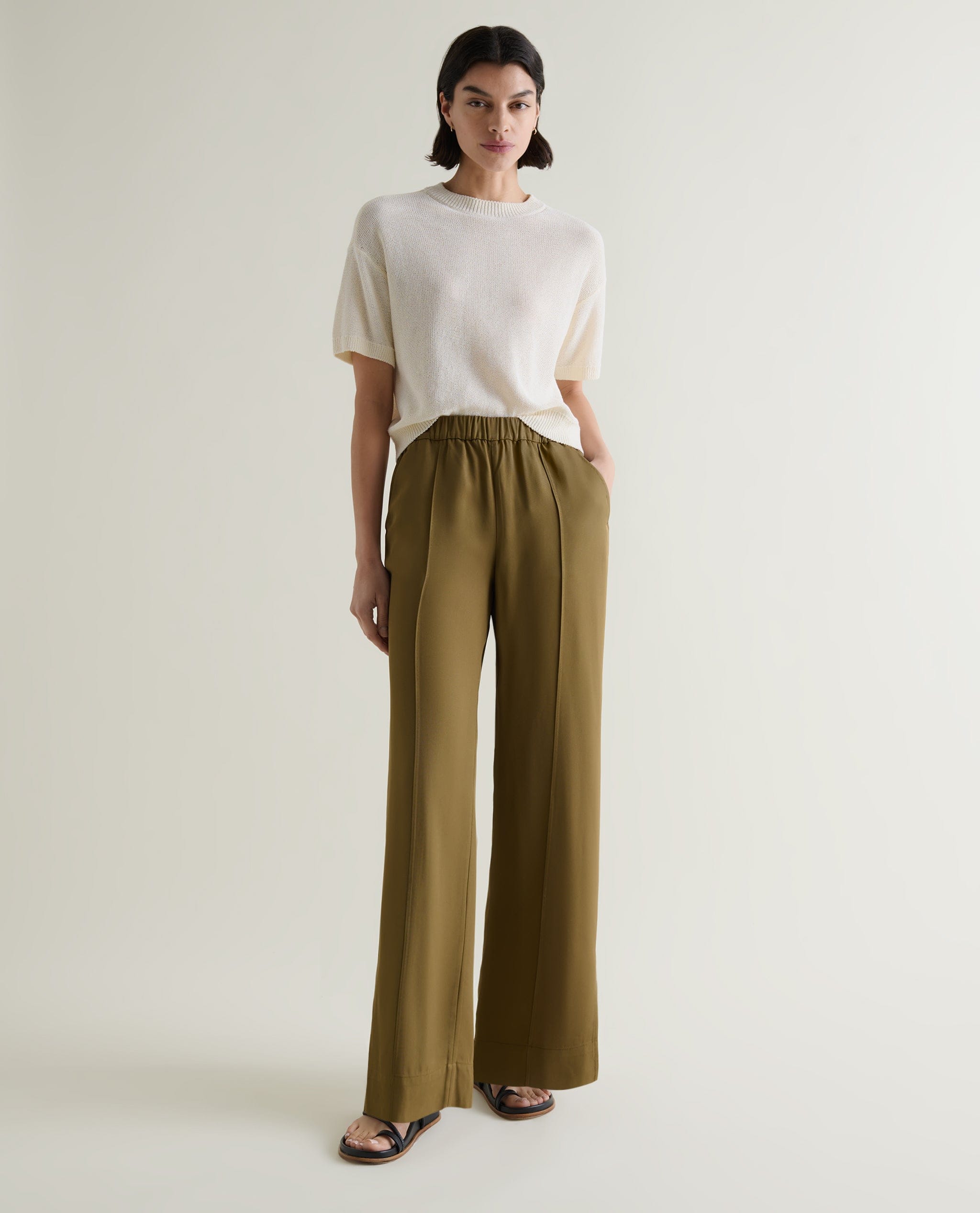 Rise & Fall's NAIA™ Tailored Track Trouser in golden olive. Matched with a cream crew neck cotton T-Shirt.