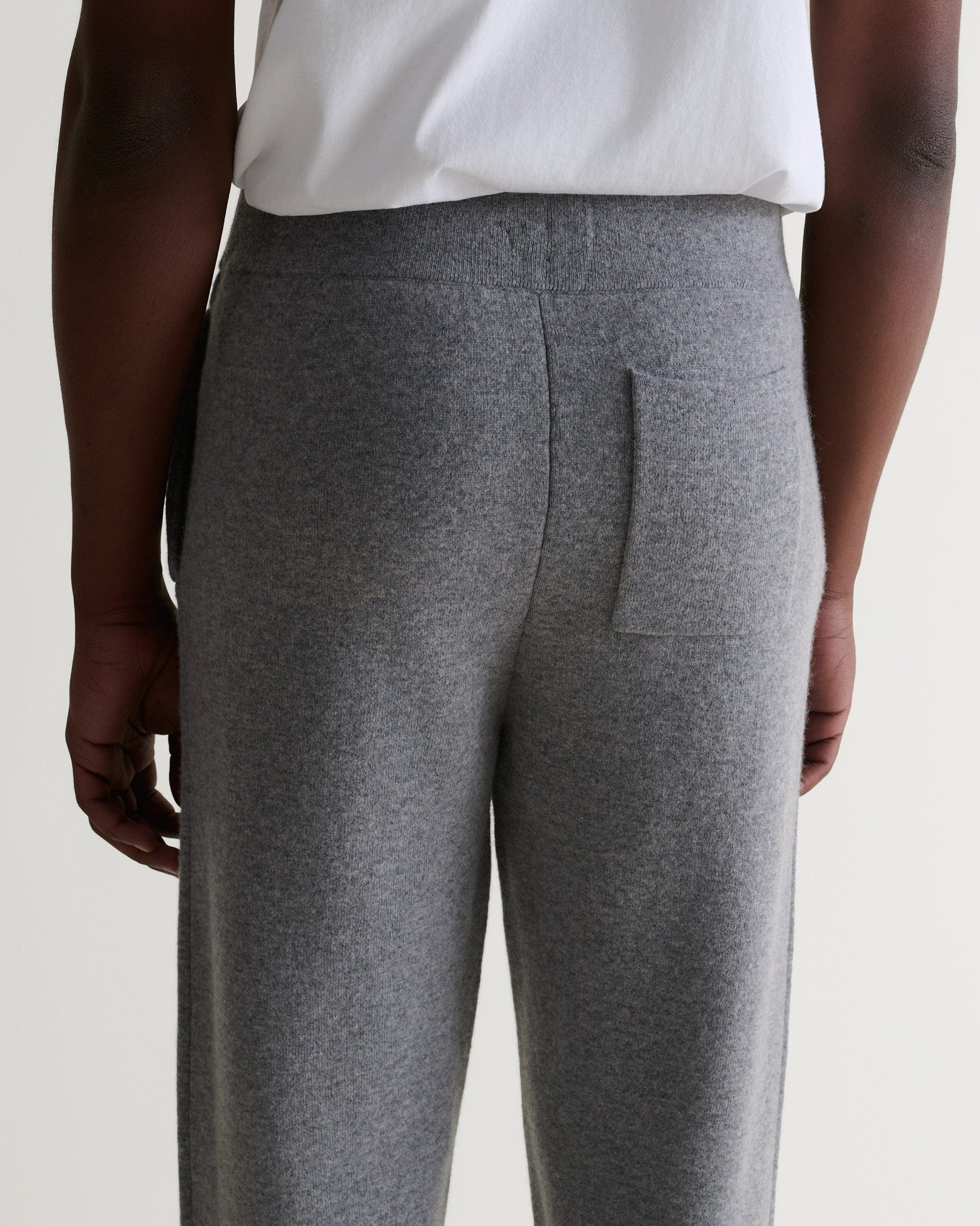 Close up top half of Rise & Fall's grey cashmere merino double-faced joggers with white T-shirt.