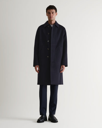 Full length front view of Rise & Fall's navy cashmere merino double-faced coat. Paired with black trousers and shoes. 