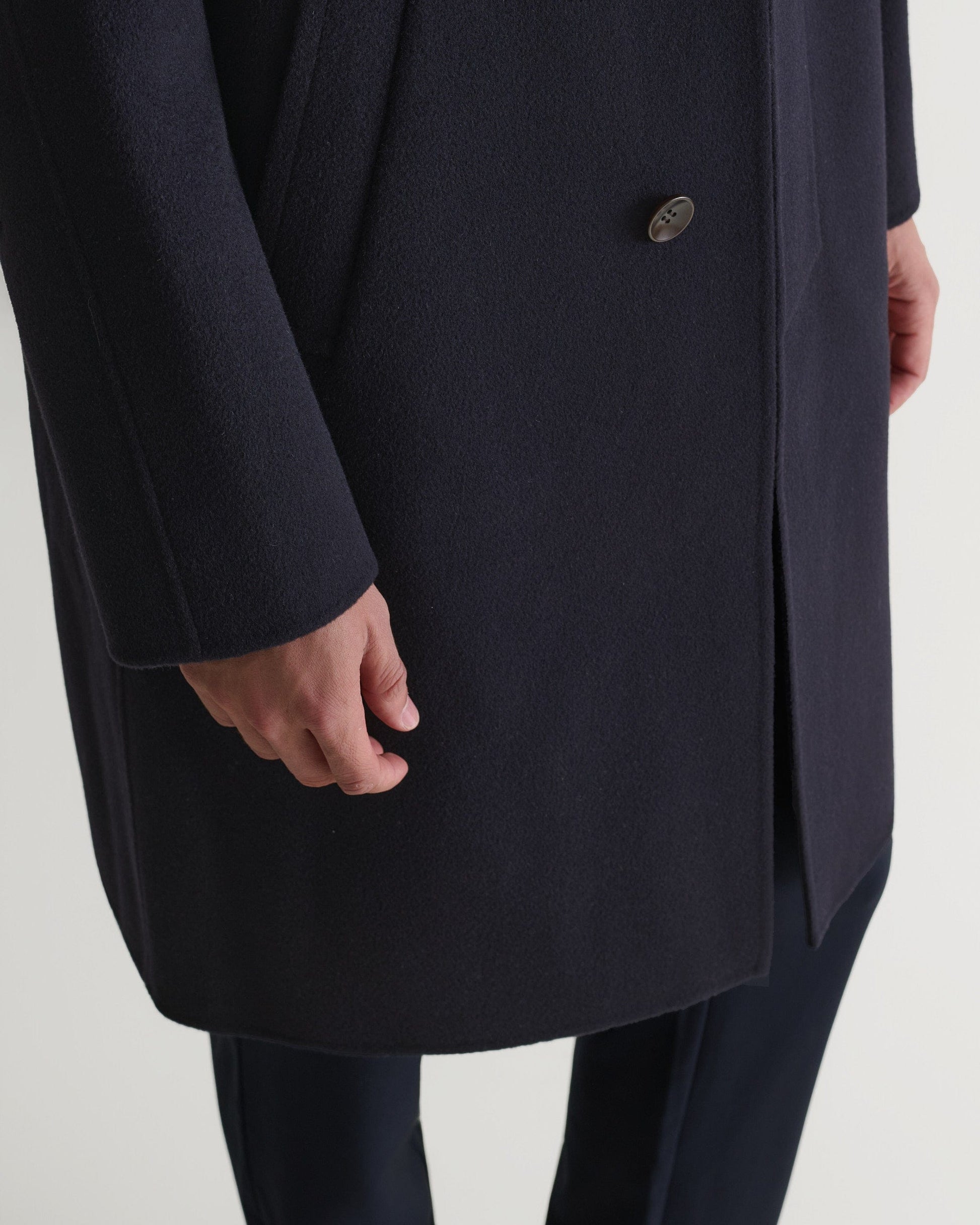 Rise & Fall's navy cashmere merino wool double-faced coat. Close up of bottom front edge.
