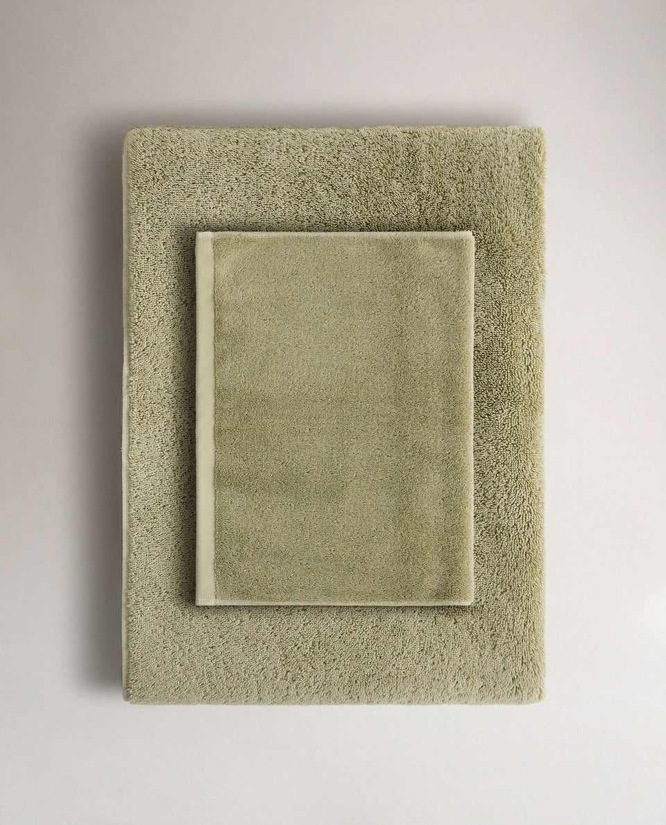 Rise & Fall's sage Turkish cotton hand towel lying on top of matching bath towel