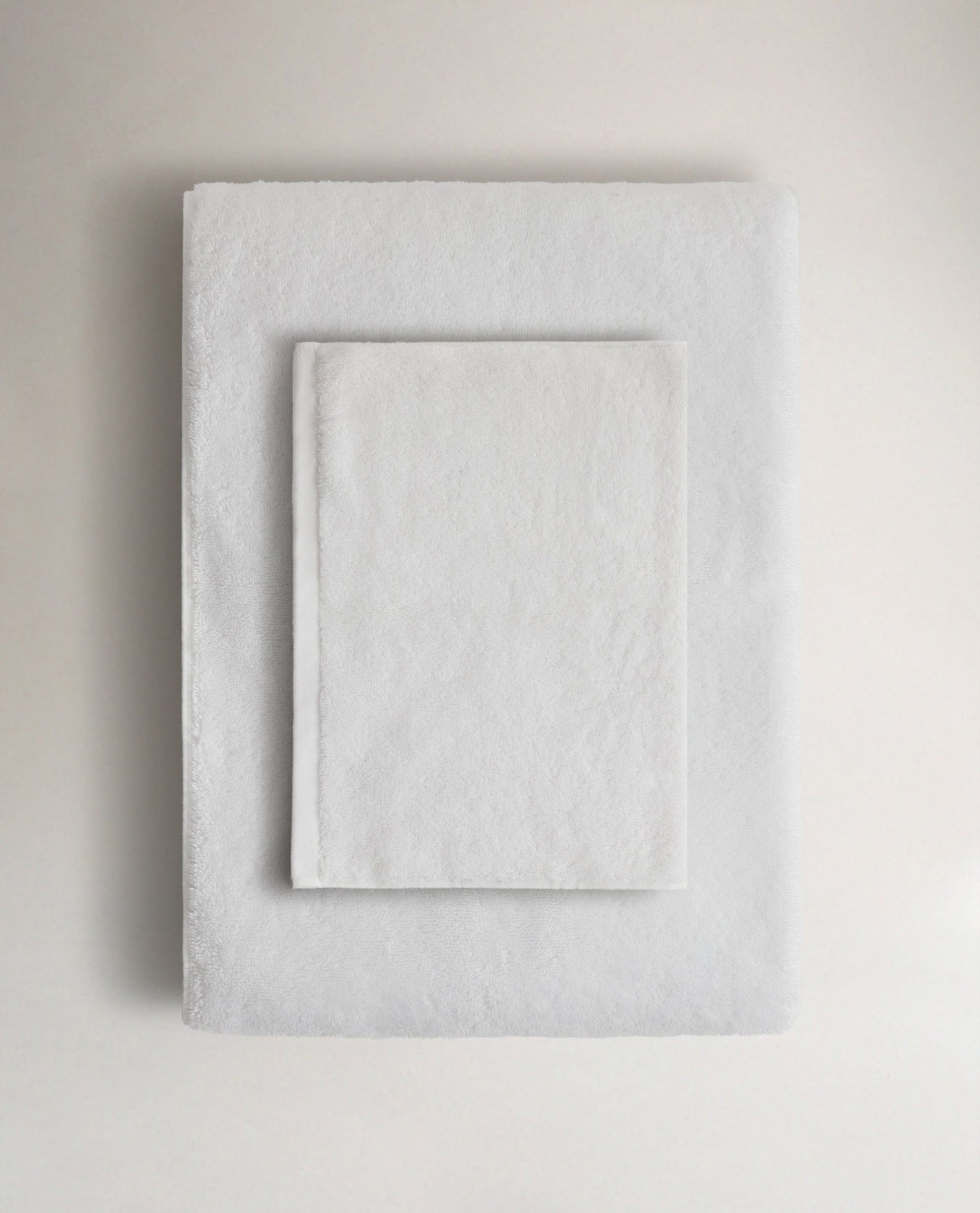 Rise & Fall's white Turkish cotton hand towel lying on top of matching bath towel