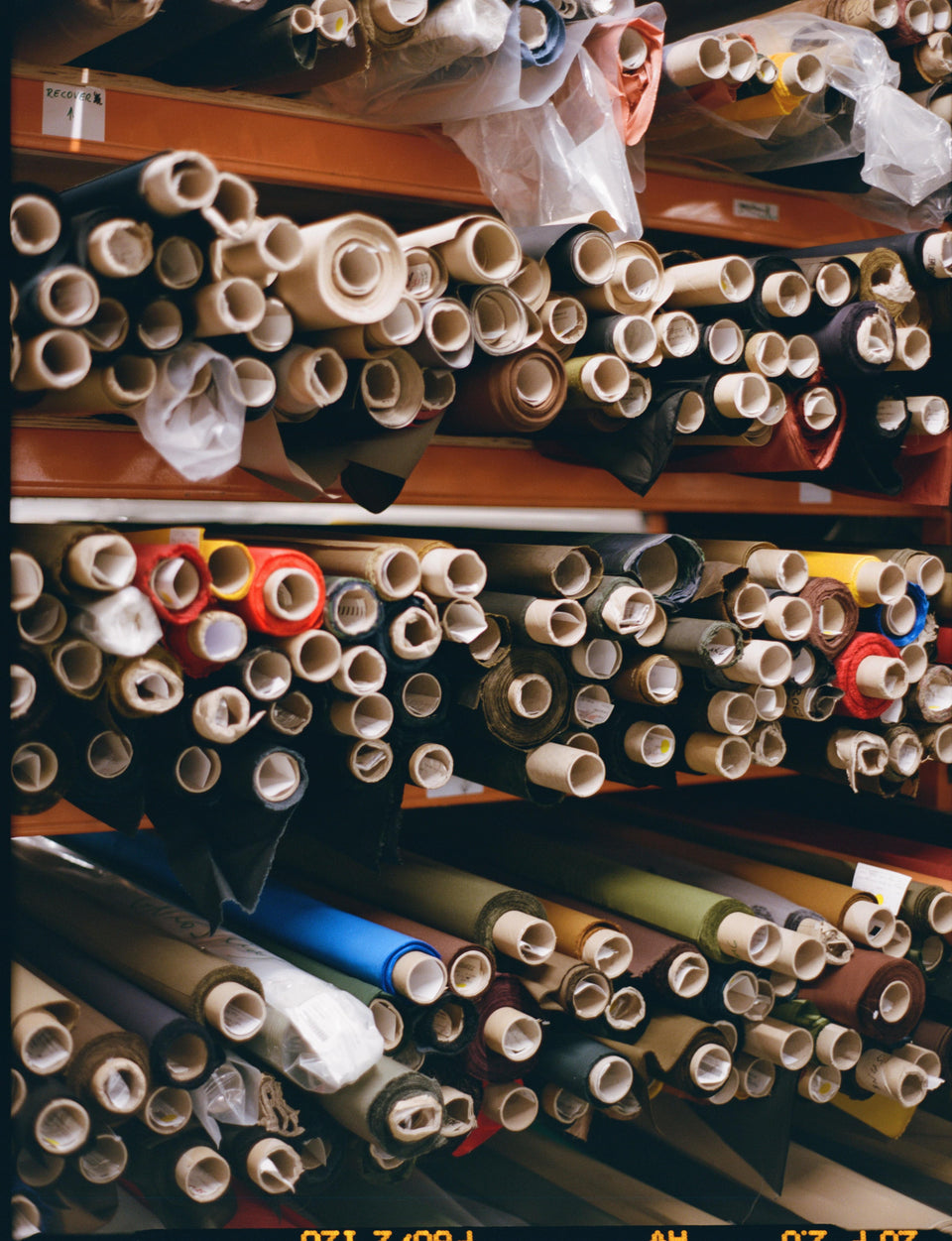 Rolls of fabric on factory shelves.