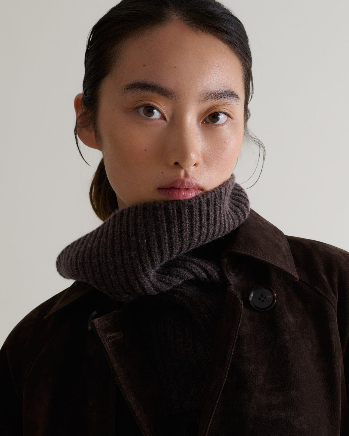 Close up of woman wearing chocolate cashmere merino ribbed collar with chocolate suede coat