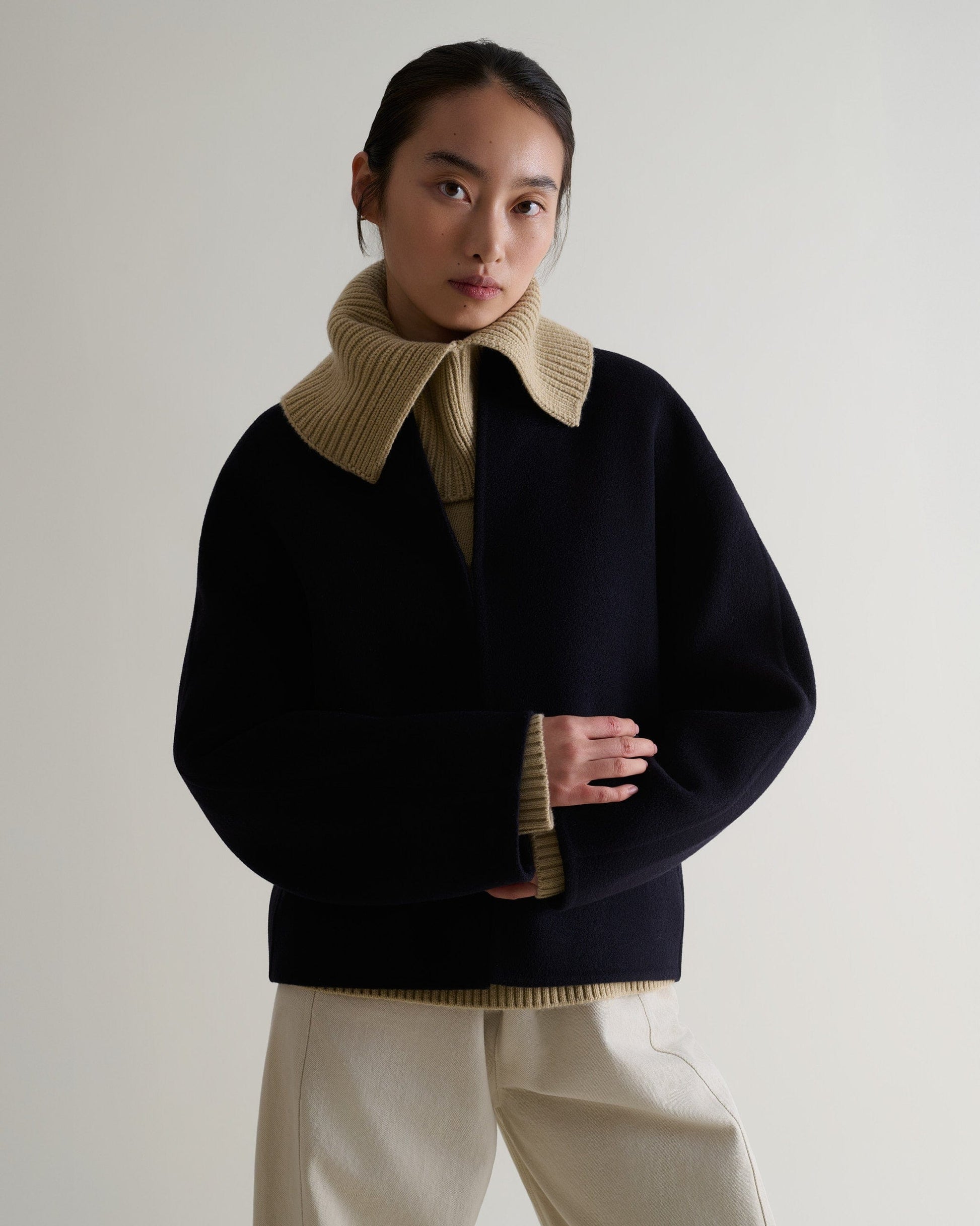 woman wearing twine cashmere-merino ribbed collar worn over dark jacket