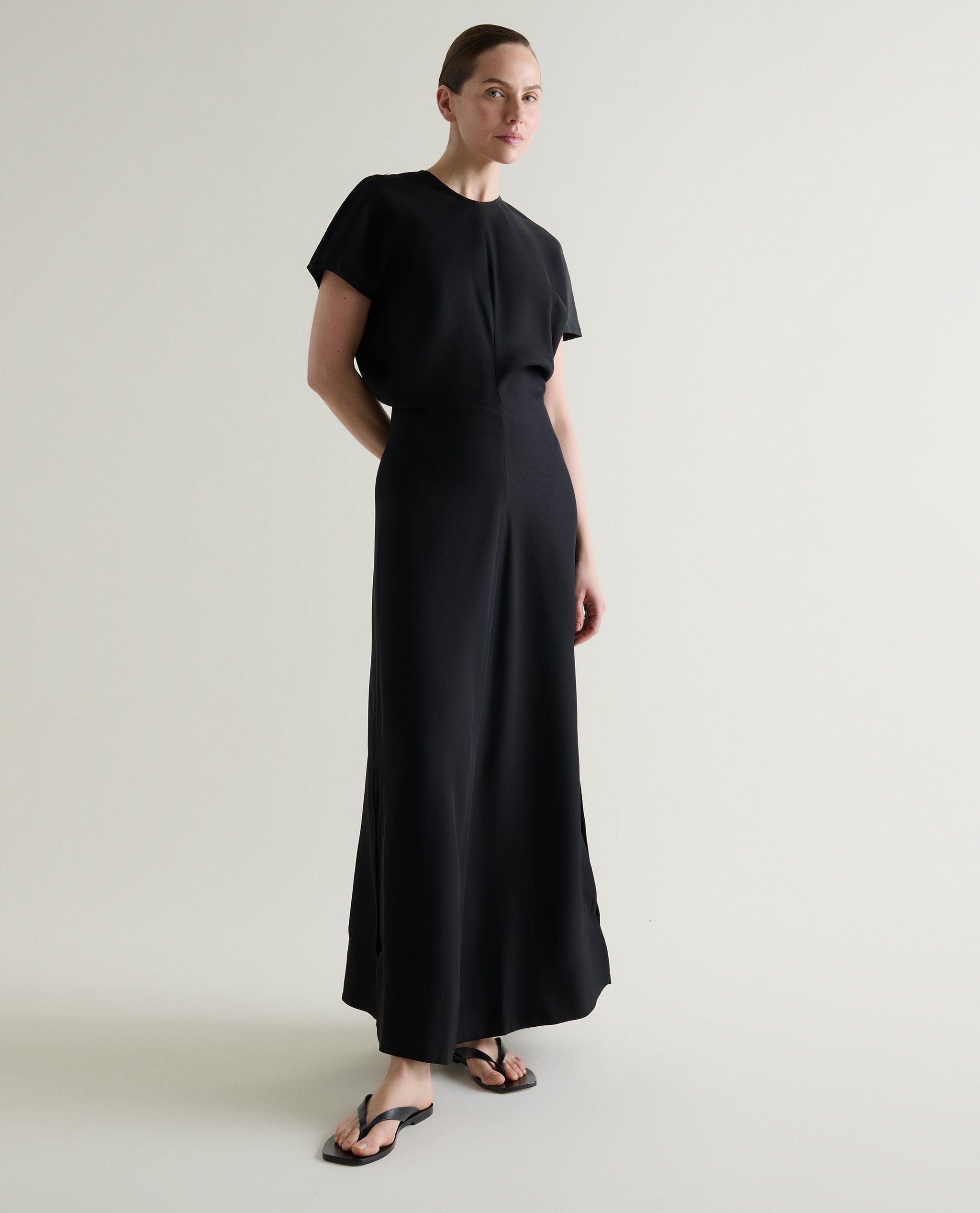 Woman wears a black Naia™ maxi dress.
